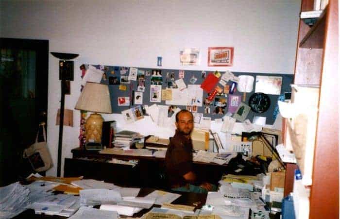 Eric Wichner in his office surrounded by papers.